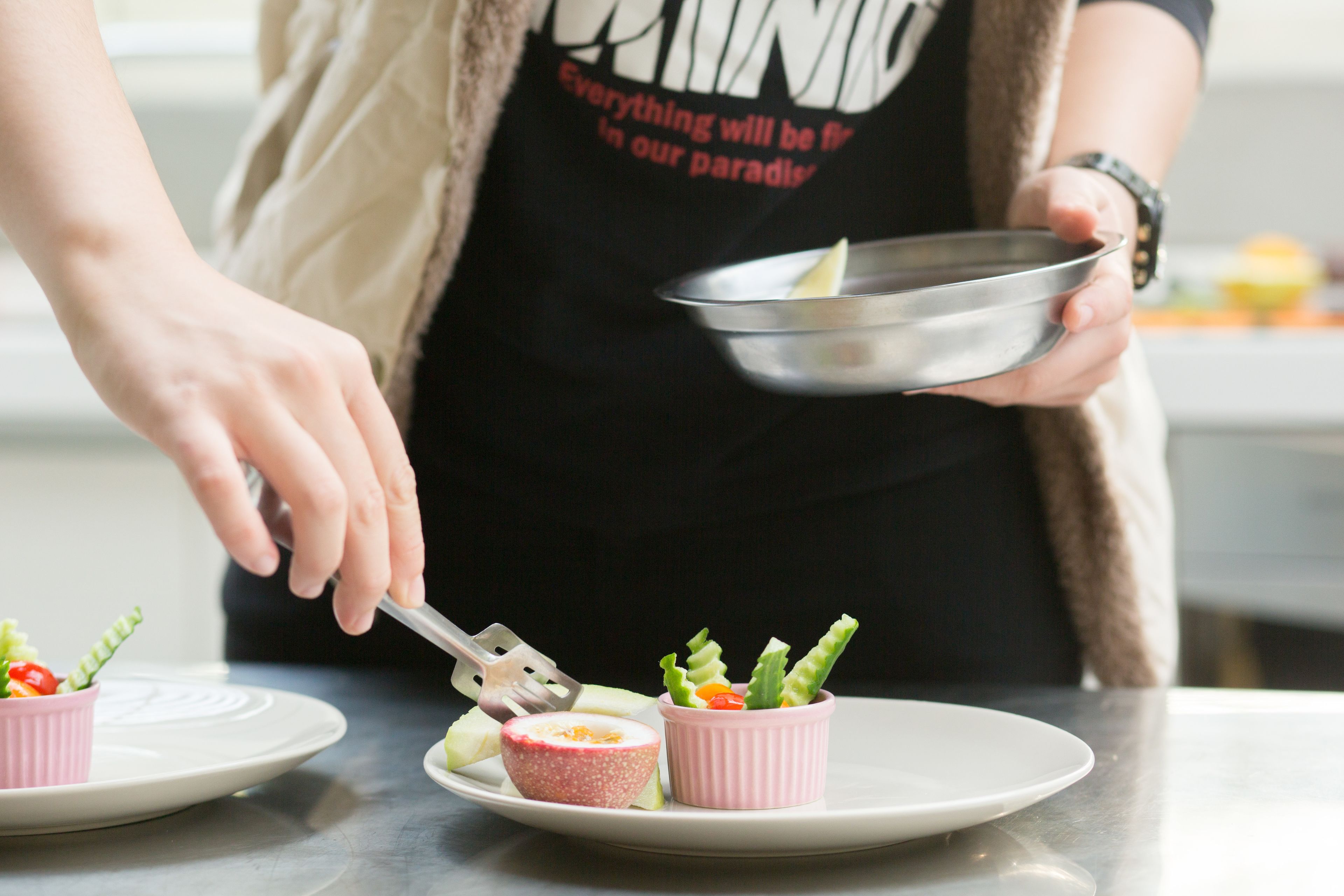 A person serving food from a bowl onto a plate.