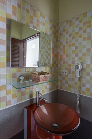 A bathroom with a glass shelf, a red sink, a mirror, and a hairdryer on the wall. - Just Like Villa (Ji'an)