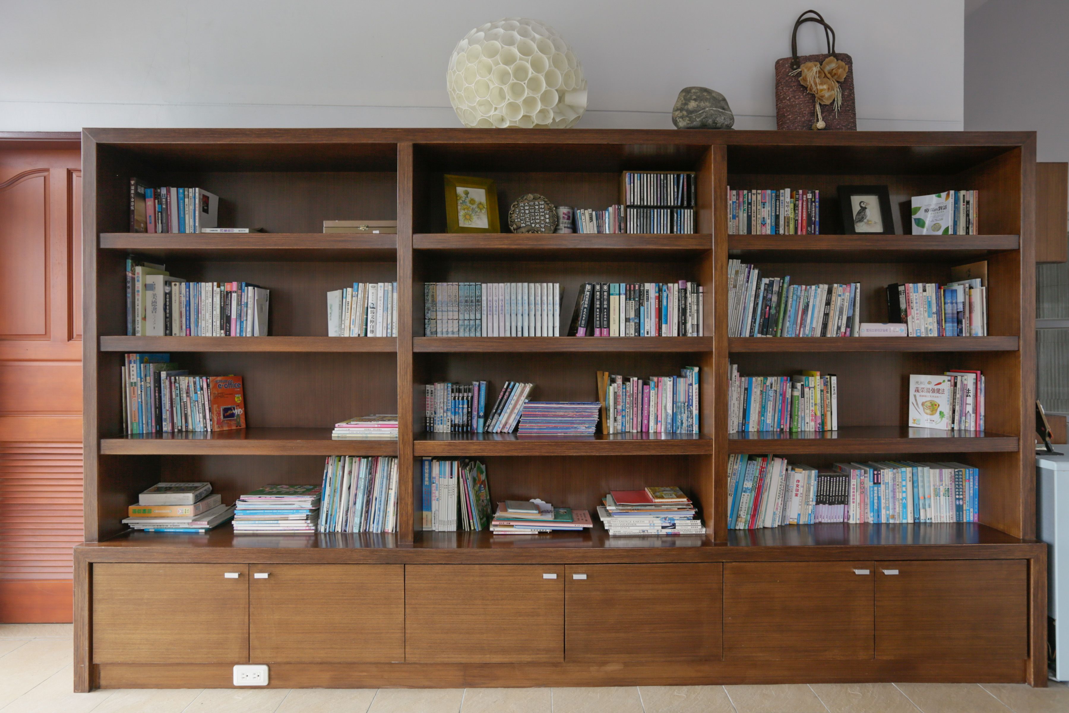 A large wooden bookshelf filled with books and decorative items.