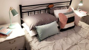 A neatly made bed with a quilted cover, two bedside tables with lamps, and a book on the left table. - Tranquil Pet friendly, close to the airport, free NBN and Netflix! (East Albury)