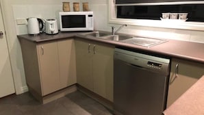 A compact kitchen with a microwave, toaster, and dishwasher. - Tranquil Pet friendly, close to the airport, free NBN and Netflix! (East Albury)