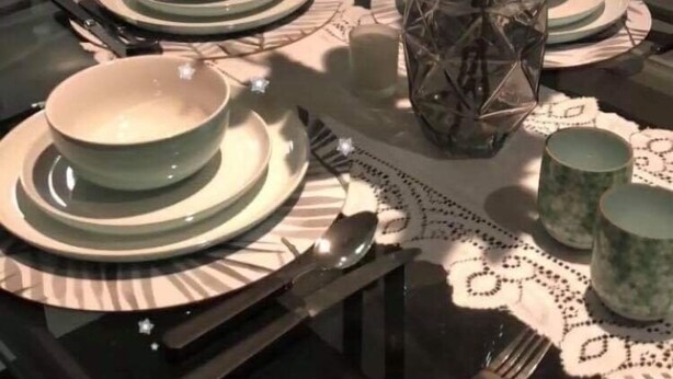 A dining table set with plates, bowls, and cutlery, a vase with flowers, and a decorative glass vase. - Tranquil Pet friendly, close to the airport, free NBN and Netflix! (East Albury)