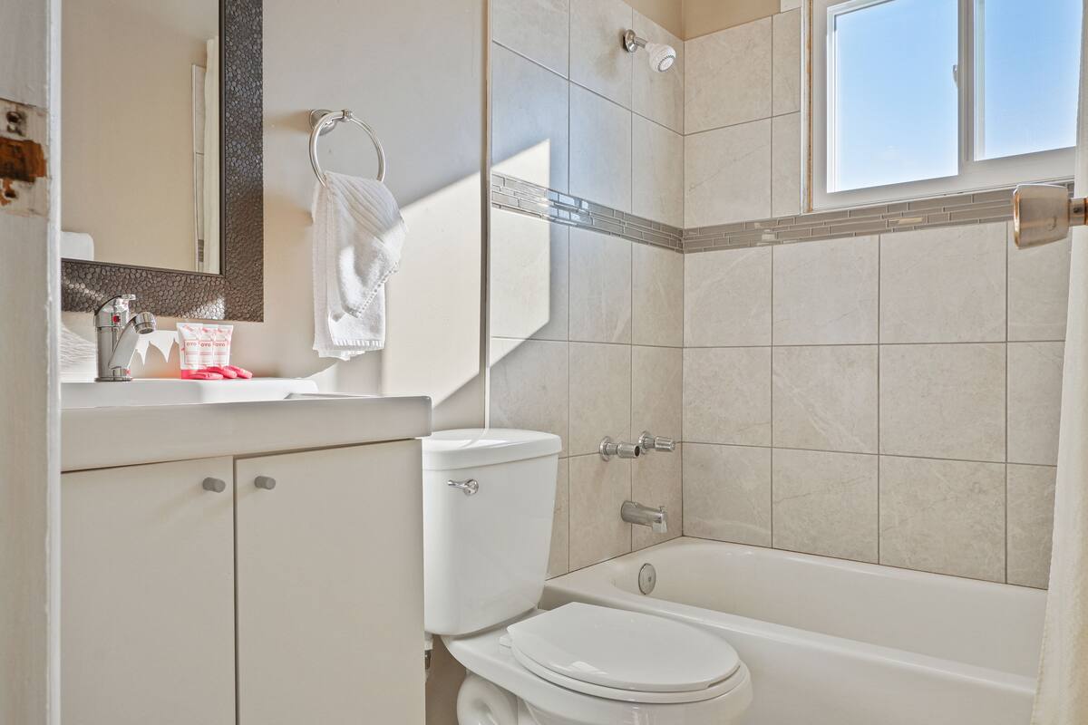 A modern bathroom with a toilet, sink, and bathtub.