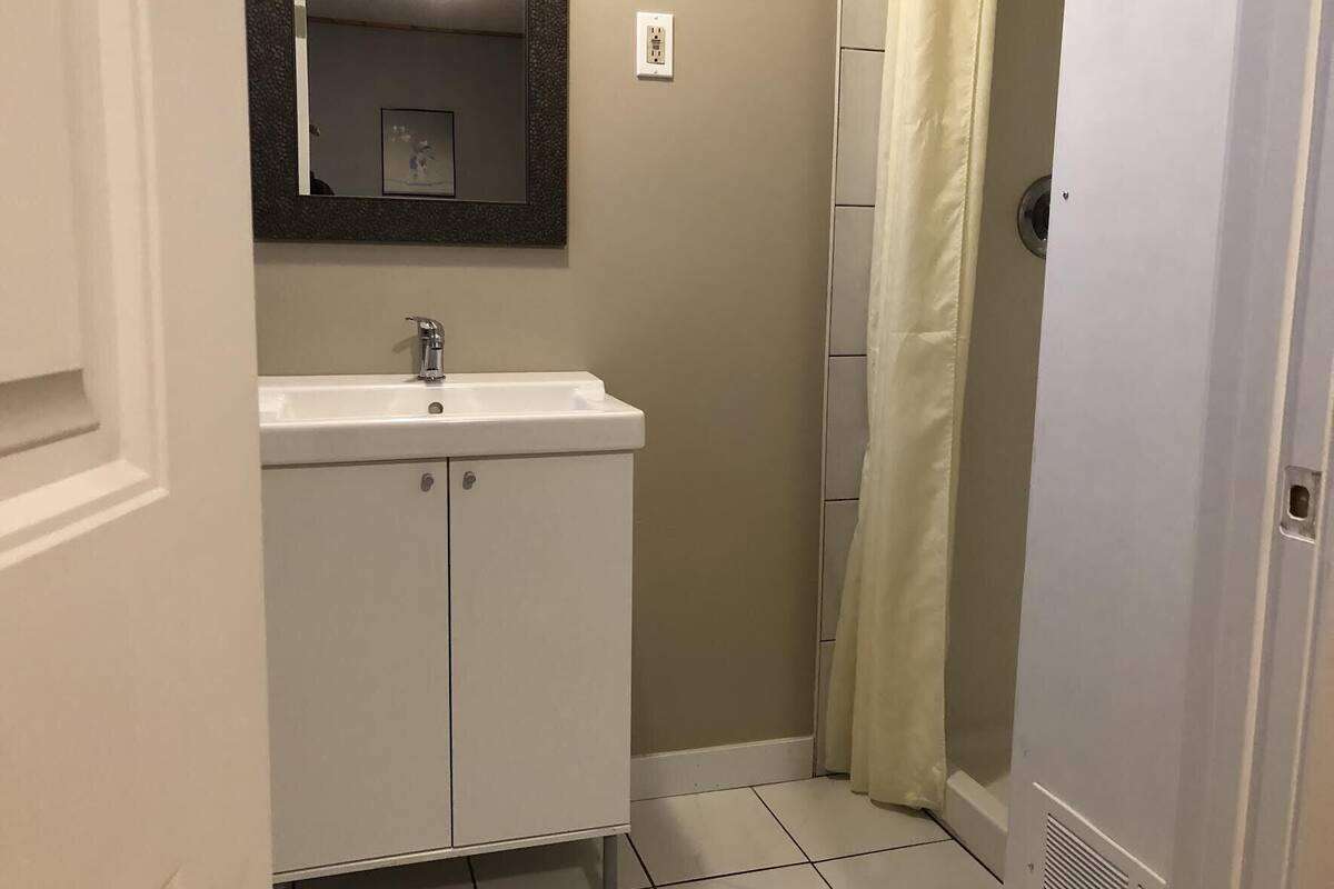 A bathroom with a white sink, a mirror, and a shower curtain.