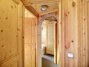 Enter a cozy space with a door leading to a room, featuring a circular light fixture above.