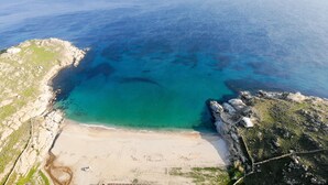An aerial view of a coastal area with a beach, rocky cliffs, and clear blue waters. - Emerald Bay 4BR House with pool by JJ Hospitality (Mikonos)