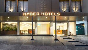 L’extérieur du bâtiment Hyper Hotels présente un design moderne, avec de grandes fenêtres en verre et une entrée imposante.