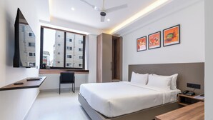 Une chambre d’hôtel moderne équipée d’un grand lit, d’un bureau, d’une chaise et d’une armoire.