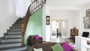 A staircase with wooden balusters, a brown sofa with three cushions, and a white cabinet. - Villetta Adriana, indipendente spaziosaluminosa (Lido di Camaiore)