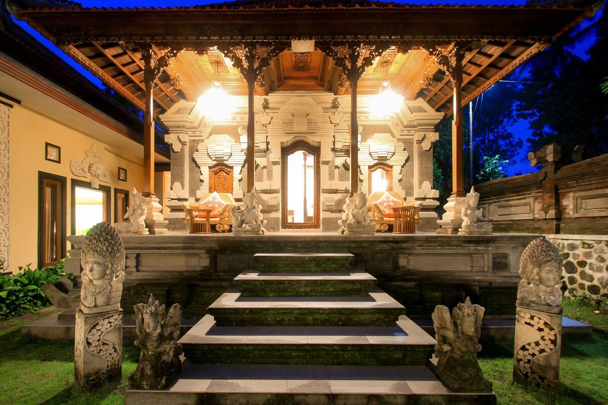A temple with a central altar, stone statues, and a staircase leading up to it.