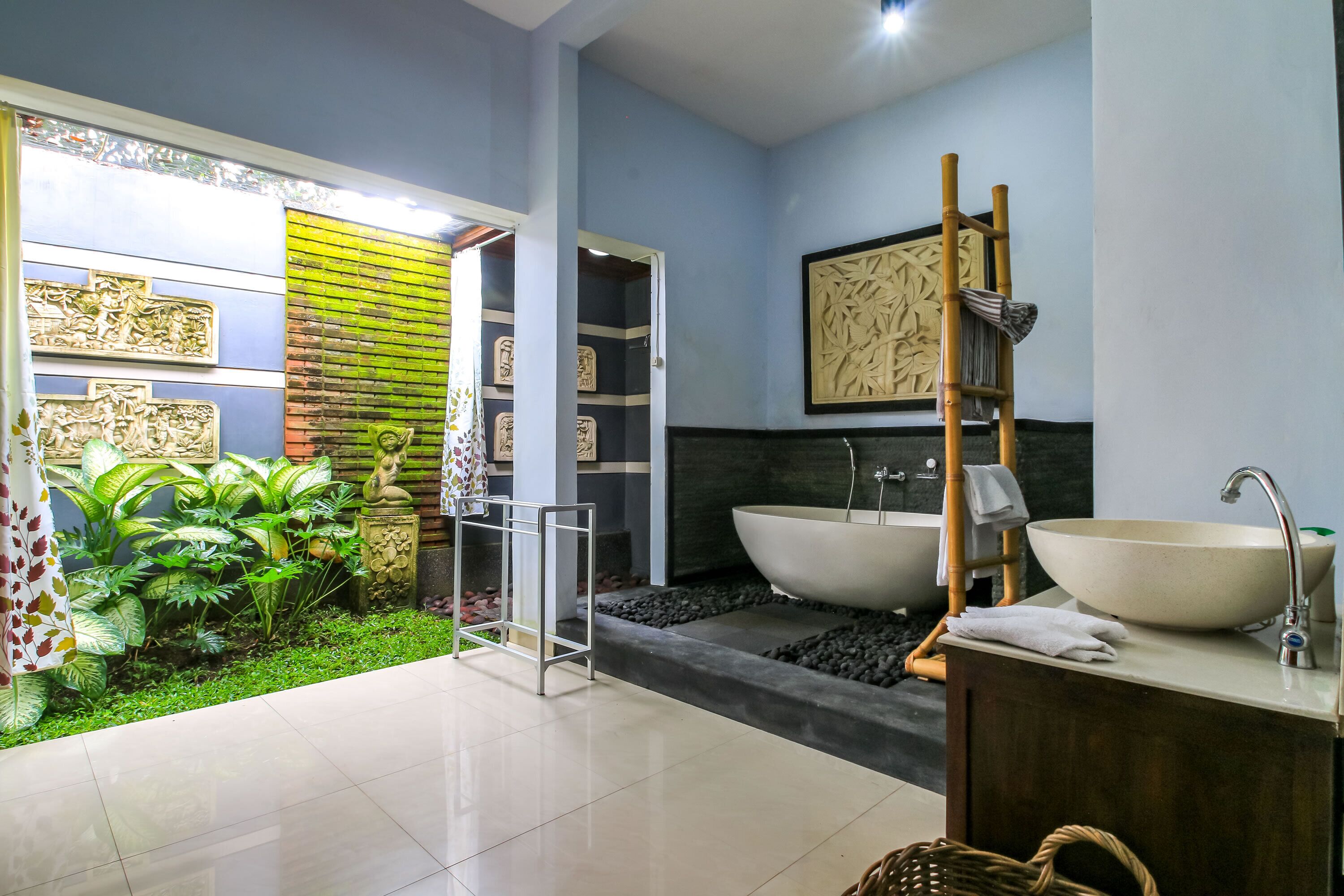 A modern bathroom with a large bathtub, a sink, and a shower area.