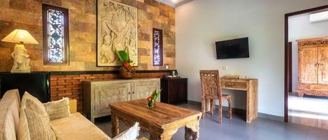 A living room with a sofa, coffee table, and a TV mounted on the wall.