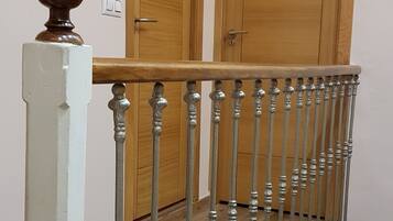 Un escalier avec une rampe en métal et des portes en bois en arrière-plan.
