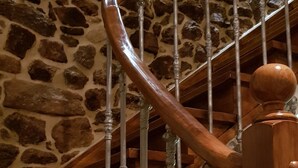 Una escala de fusta amb un mur de pedra de fons.
