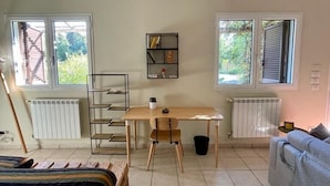 A room with a bed, a desk, a chair, a radiator, and a window. - Apartment with Garden View (Lecce)
