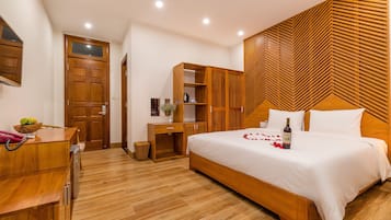 A bedroom with a wooden bed, a desk, and a wardrobe.