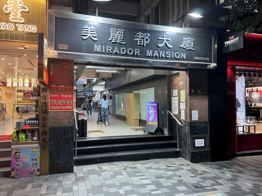 A hotel entrance with a sign reading 'MIRADOR MANSION' and a visible staircase leading inside.