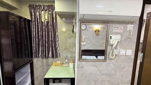 A bathroom with a mirror, a clock, a no-smoking sign, a telephone, and a minibar. - Sleep Inn (Kowloon)