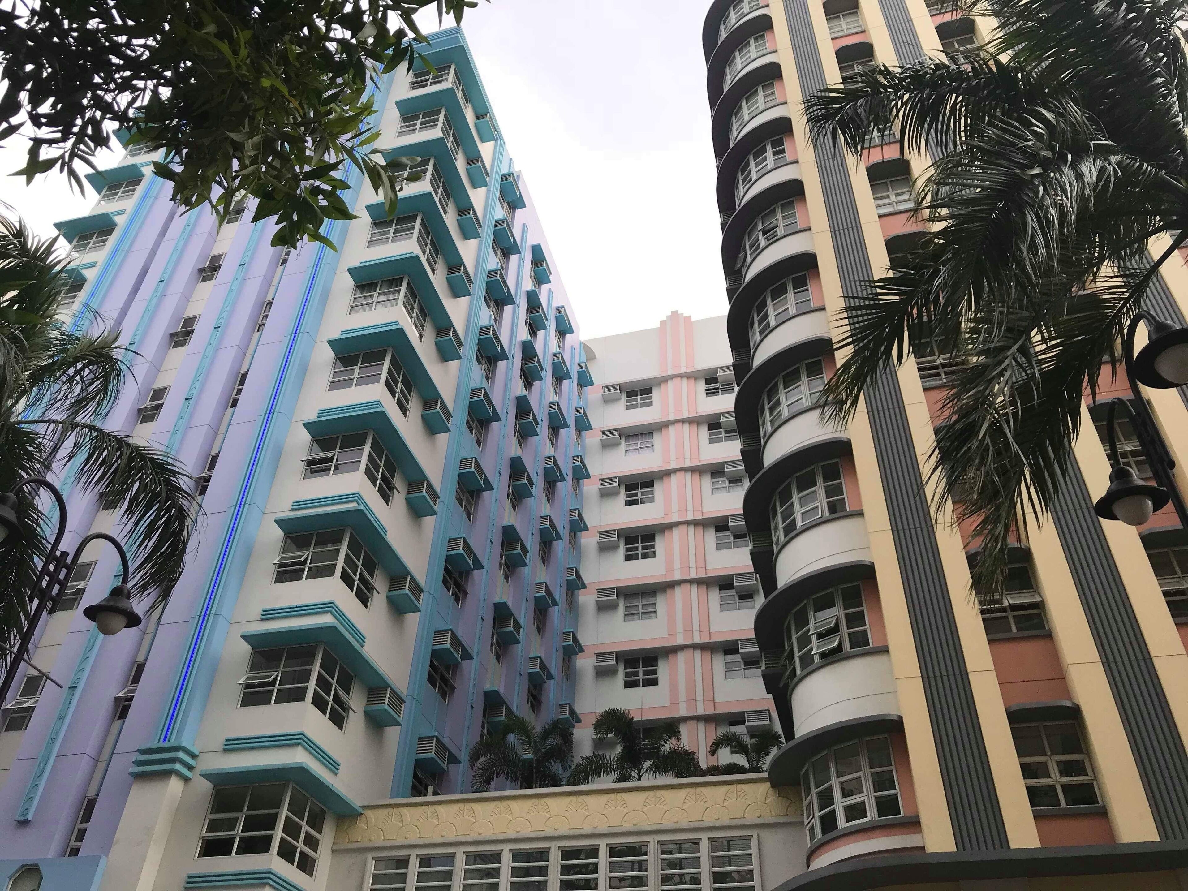 Un immeuble à plusieurs étages, doté de balcons et d’une entrée centrale.