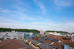 A residential area with multiple houses, a clear sky, and a distant airplane. - Narita AIC Airport Hotel (Narita)