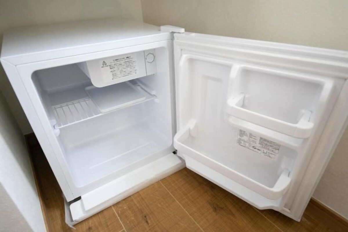 Ein offener Kühlschrank mit zwei Einlegeböden und einem Gefrierfach.