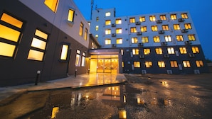 A hotel with a modern design, featuring a large entrance and multiple windows.