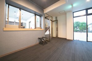 A modern hotel room with a large window, carpeted floor, and a small wooden bench. - Narita AIC Airport Hotel (Narita)
