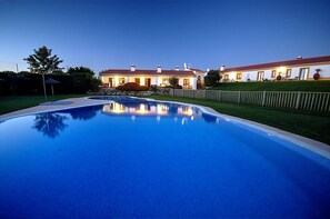 A large swimming pool with a house in the background.