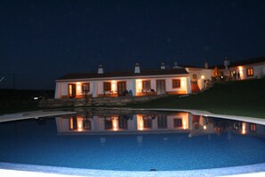 A large house with a swimming pool in the foreground.