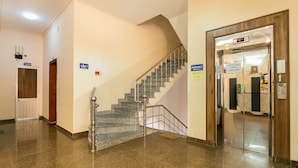 A hotel lobby with a staircase, a reception desk, and an elevator. - Star Hotel (Ho Chi Minh City)
