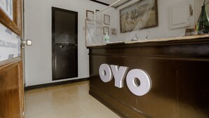 A reception desk with the name 'OYO' prominently displayed. - OYO 741 Sierra Travellers Inns (Tagaytay)