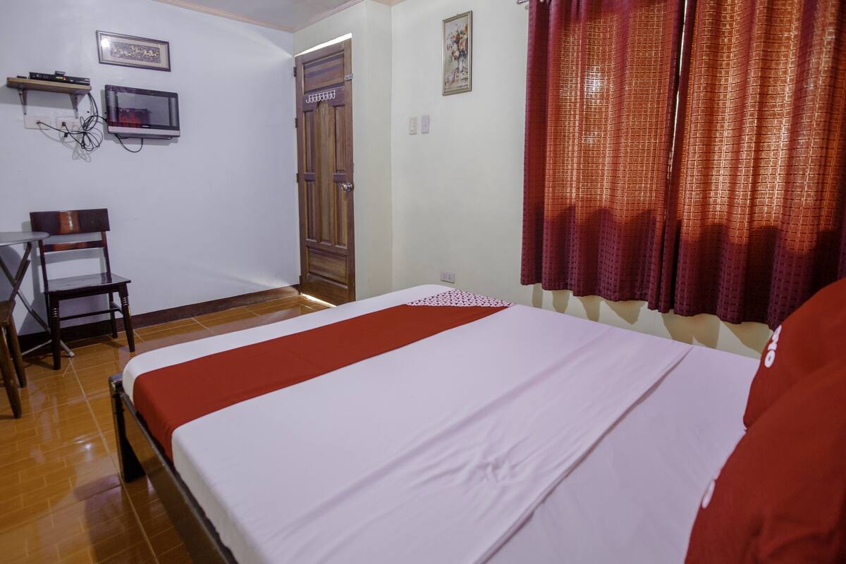 Una habitación de hotel con una cama, un escritorio y una silla.