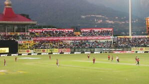 A stadium with multiple tiers of seating, advertisements, and a mountainous backdrop. - Highland Village Resort (Dharamshala)