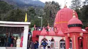 A temple with red domes and a white building with a yellow flag. - Highland Village Resort (Dharamshala)