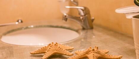A bathroom sink with two starfish-shaped soap dishes.