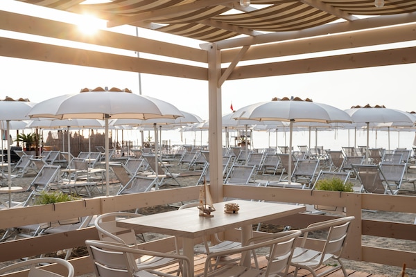 Una spiaggia nelle vicinanze, lettini da mare, ombrelloni