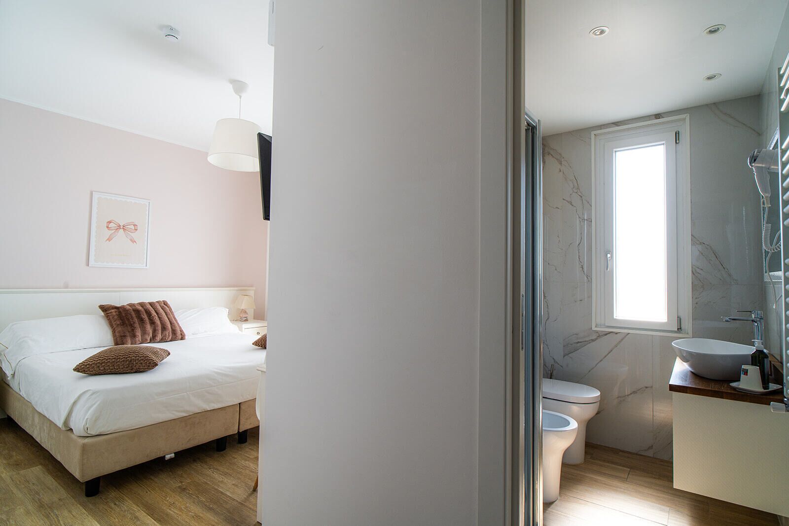 Ein Schlafzimmer mit Bett, Nachttisch und einem am Wand montierten Fernseher.