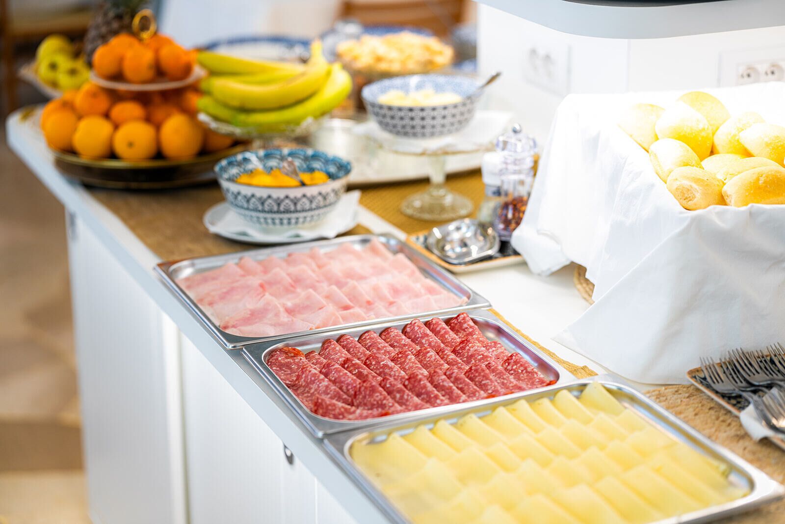 Buffet com diversas opções de comida, incluindo carnes, frutas e produtos de panificação.