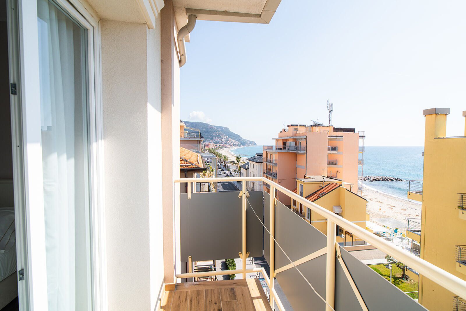 Een balkon met uitzicht op een strand en gebouwen.