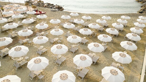 A beach with rows of white umbrellas and lounge chairs. - Hotel Continental (Pietra Ligure)