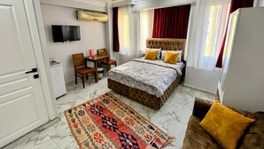 A hotel room with a bed, a TV, a desk, and a chair. - Pembe Hotel (Istanbul)