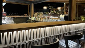 Un espace bar avec un comptoir en bois et des sièges.