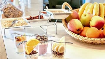 A breakfast buffet with various food items and a fruit basket.