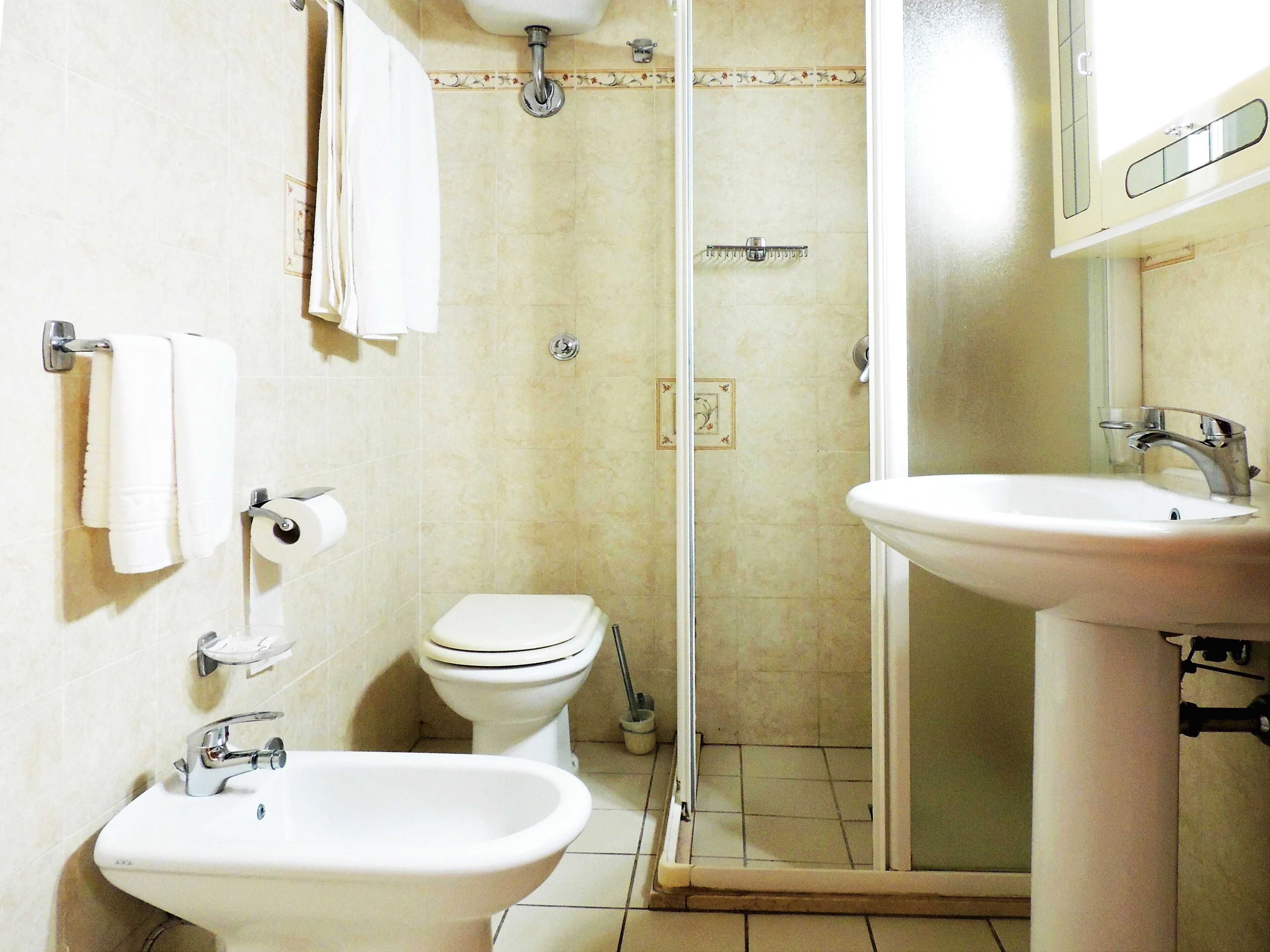 Ein Badezimmer mit Bidet, Toilette und Waschbecken.