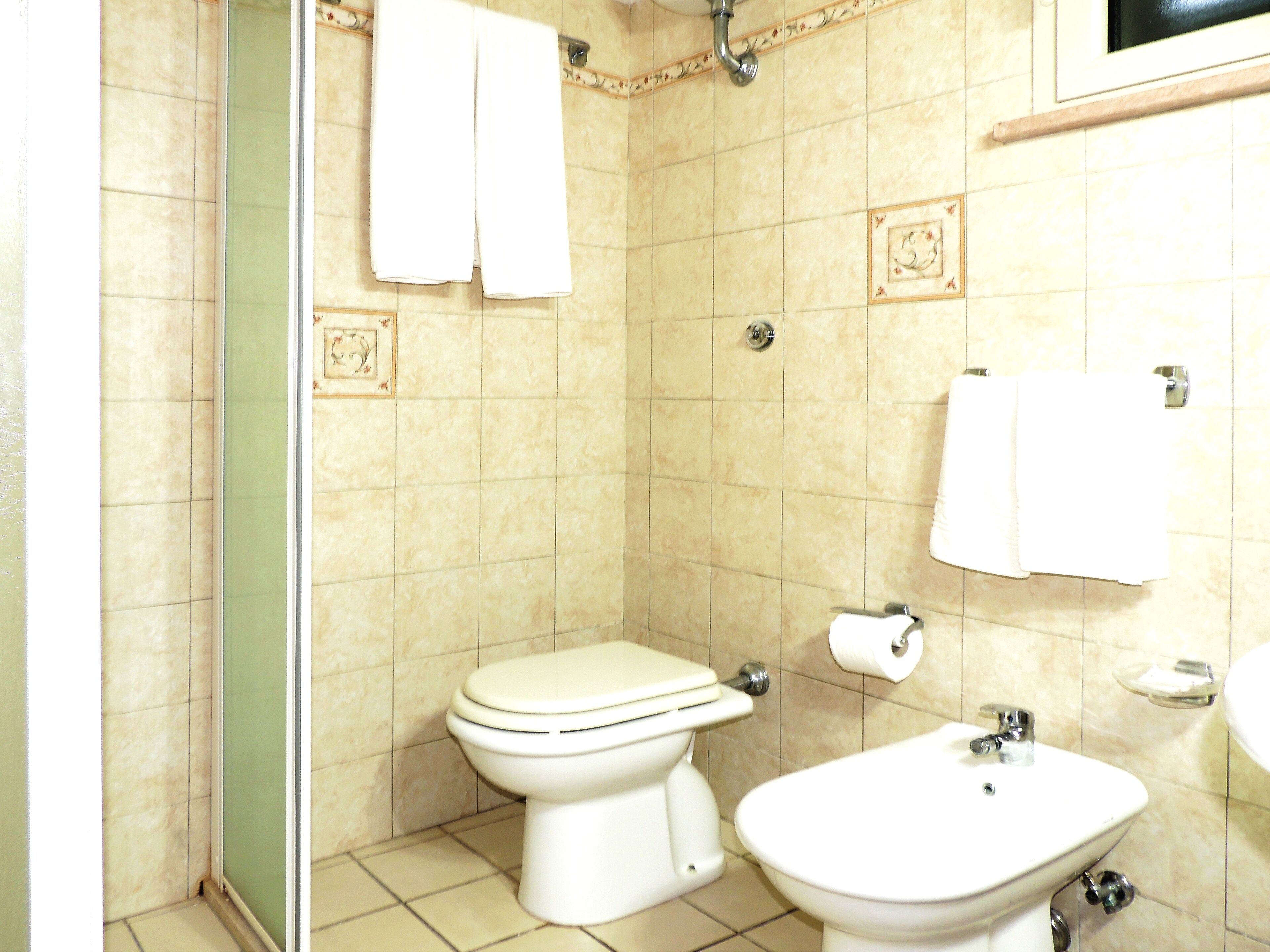 Un baño con inodoro, bidé y lavamanos.