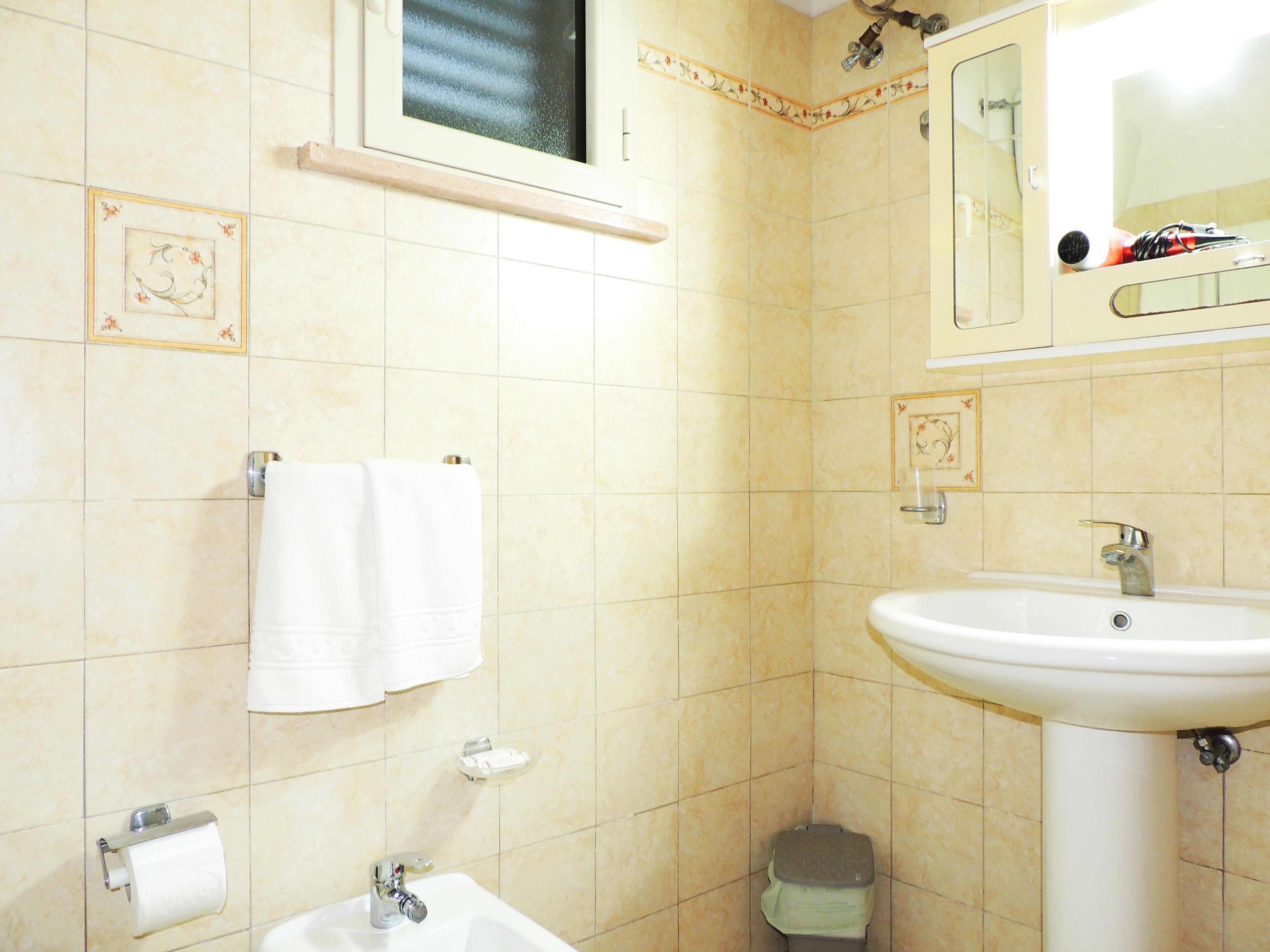 A bathroom with a sink, mirror, towel rack, and toilet.