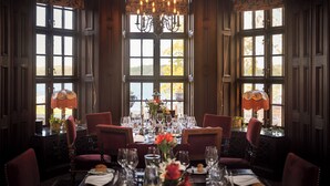 A dining room with a large table set for a meal, surrounded by chairs, and large windows with curtains. - Engsholms Slott - Adults Only (Morko)
