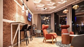 Een modern interieur met een bakstenen muur, houten vloer en stadszicht door grote ramen.