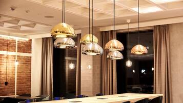 A conference room with a long table, multiple chairs, and pendant lighting.