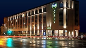 Een modern hotelgebouw met een opvallend bord waarop staat dat het een B&B hotel is.
